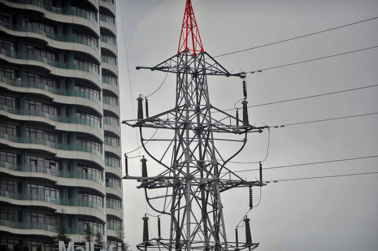 This picture shows an electrical pylon standing beside a building in Istanbul on March 31, 2015, during a massive power outage.  A massive power cut caused chaos across Turkey, shutting down the metro networks in Istanbul and the capital Ankara, with the government saying an outside attack on the system was not ruled out.   AFP PHOTO/OZAN KOSE