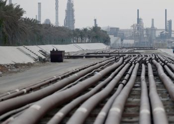 Residents are seen doing their evening walk near the petroleum pipelines as State run Bahrain Petroleum Co (Bapco) refinery is seen at the back, in Ma'ameer village, south of Manama